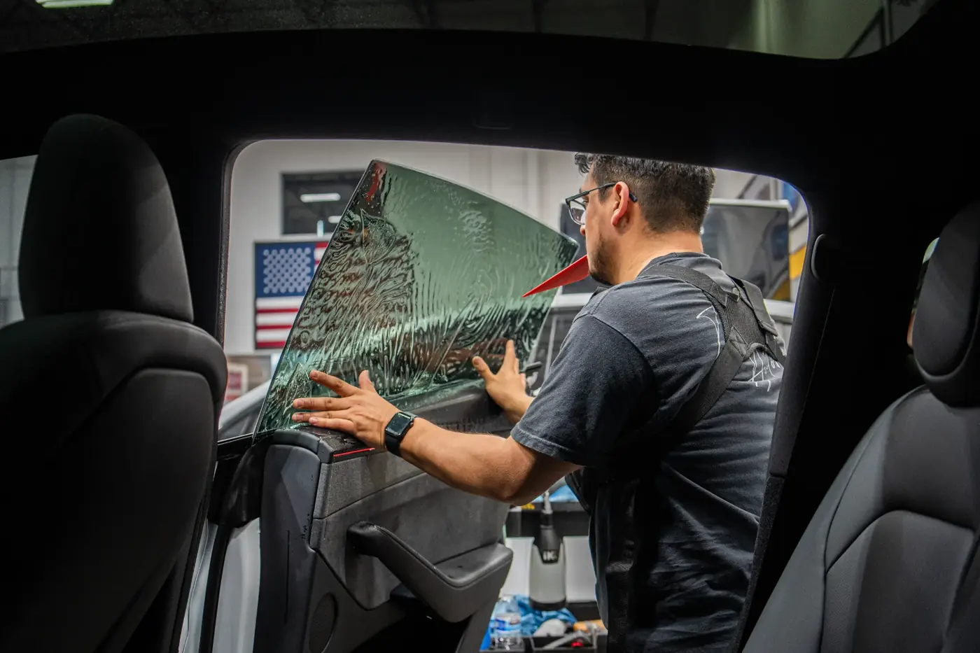 Tier 1 Autohaus installing window tint on a vehicle side window